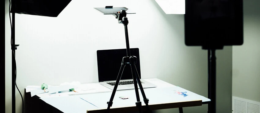Close-up of a photographer holding a camera, representing the contrast between in-house and freelance photography careers.