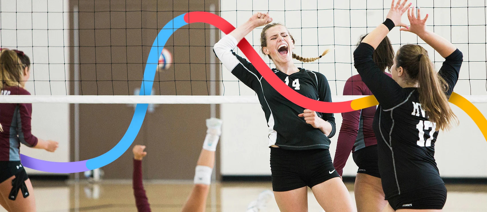 A close-up of female volleyball players in mid-air attempting a shot during an indoor match.